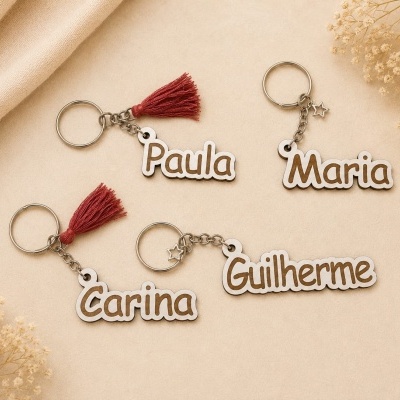 Porta-chaves personalizados com nomes Paula, Maria, Carina e Guilherme, com borlas vermelhas e pendentes de estrela em fundo bege.