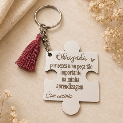 Porta-chaves puzzle branco com texto e tassel rosa sobre fundo claro com flores secas