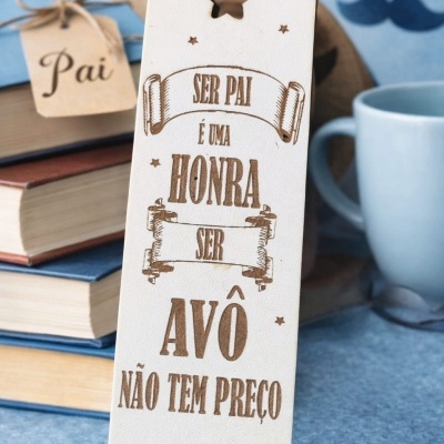 Placa de madeira clara com mensagem para pais e avós, decorada com estrelas e recorte estrela.