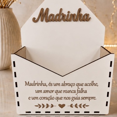 Caixa decorativa branca em forma de envelope com mensagem para madrinha e vaso com flores secas ao lado