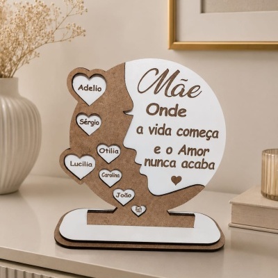 Objeto decorativo de madeira em formato de rosto feminino com corações brancos e texto alusivo à mãe