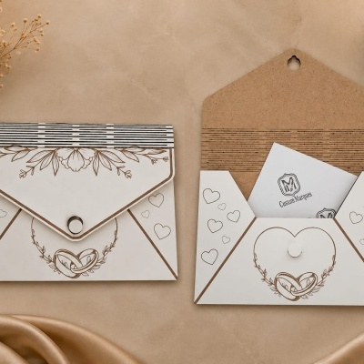 Dois envelopes brancos decorados com ilustrações douradas e cartão visível