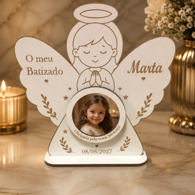 Moldura de anjo em madeira com foto e texto sobre batizado num ambiente decorado com velas e flores