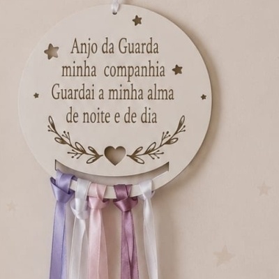 Placa decorativa branca redonda com texto e fitas coloridas penduradas