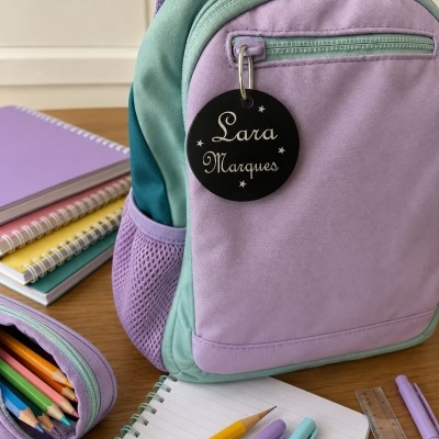 Mochila infantil lilás e verde-água com etiqueta preta personalizada e material escolar