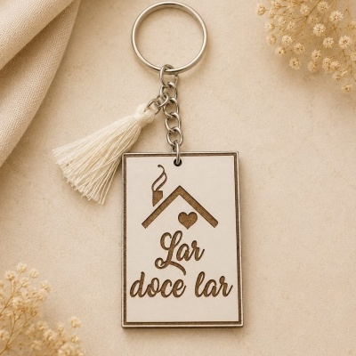 Chaveiro de madeira com frase Lar doce lar e borla creme sobre fundo bege
