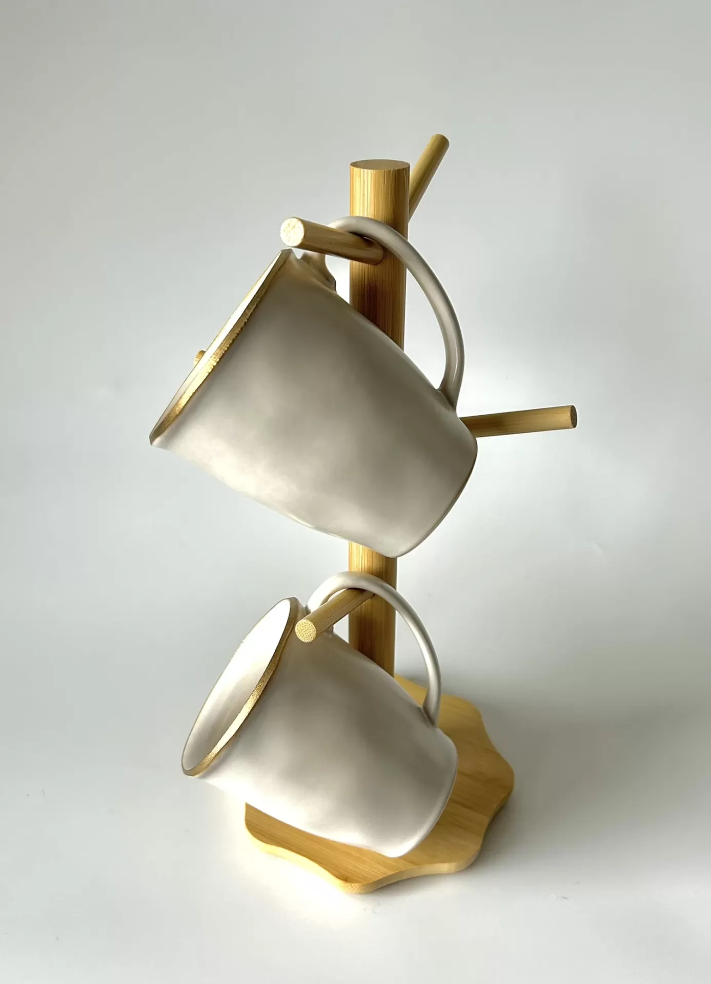 Duas canecas cinzentas com bordas douradas num suporte de madeira