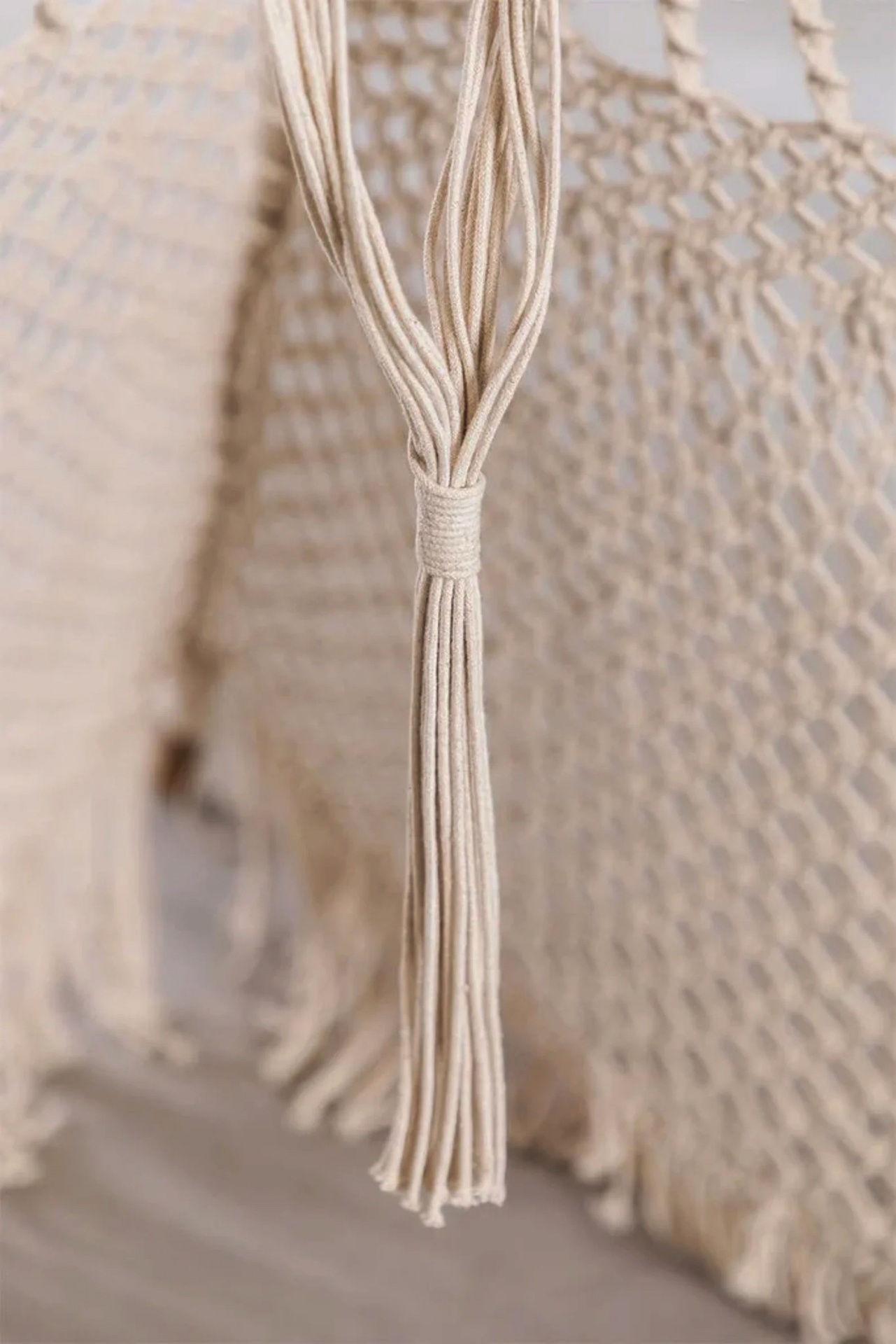 Rede de macramé bege com tassel e padrão entrelaçado
