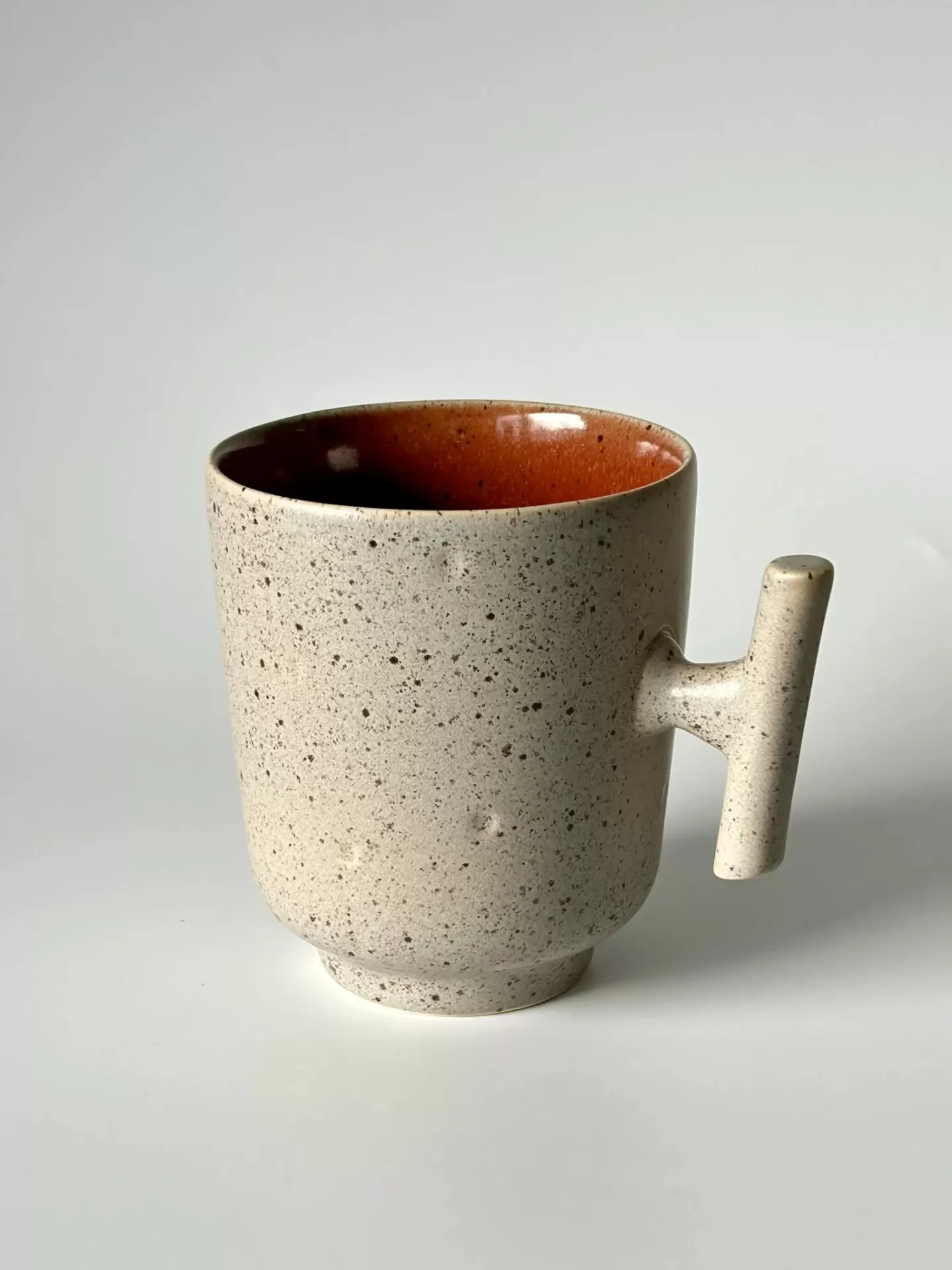 caneca de cerâmica salpicada bege com interior castanho