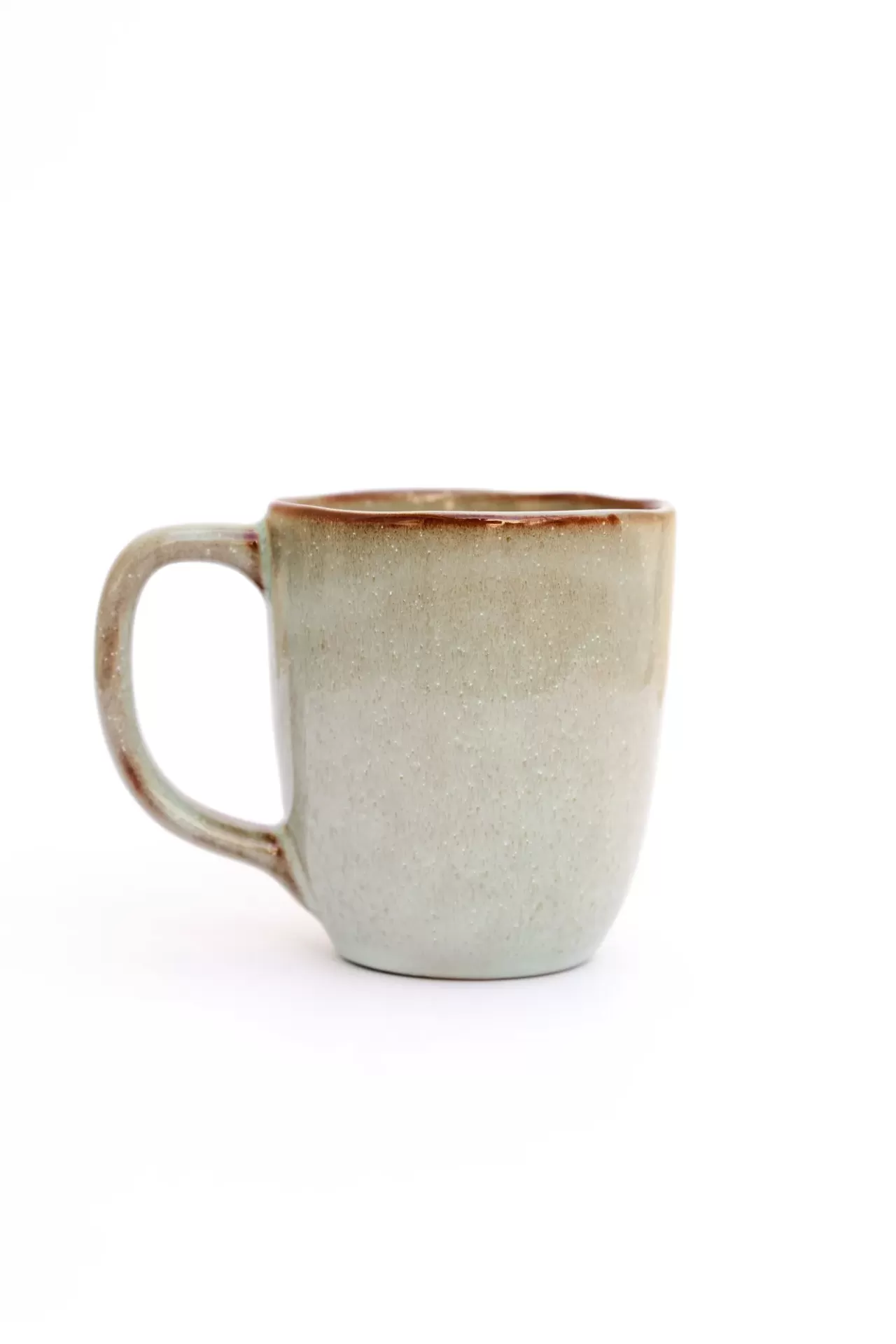 Caneca de cerâmica bege com borda castanha em fundo branco