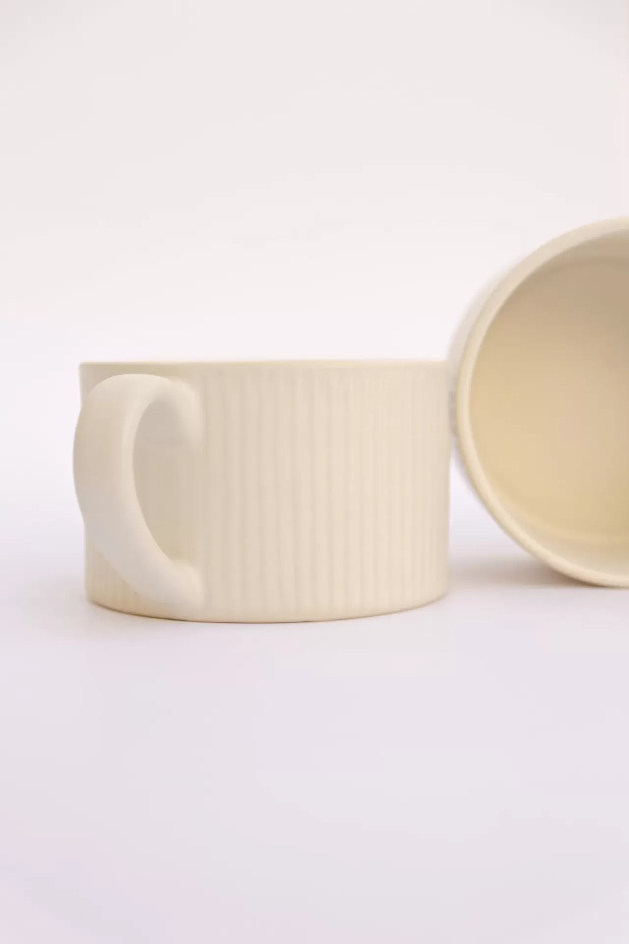Duas chávenas de cerâmica creme com textura de linhas verticais