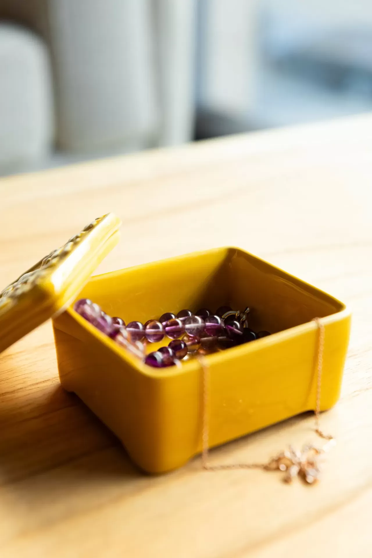 caixa amarela quadrada em cerâmica com joias dentro