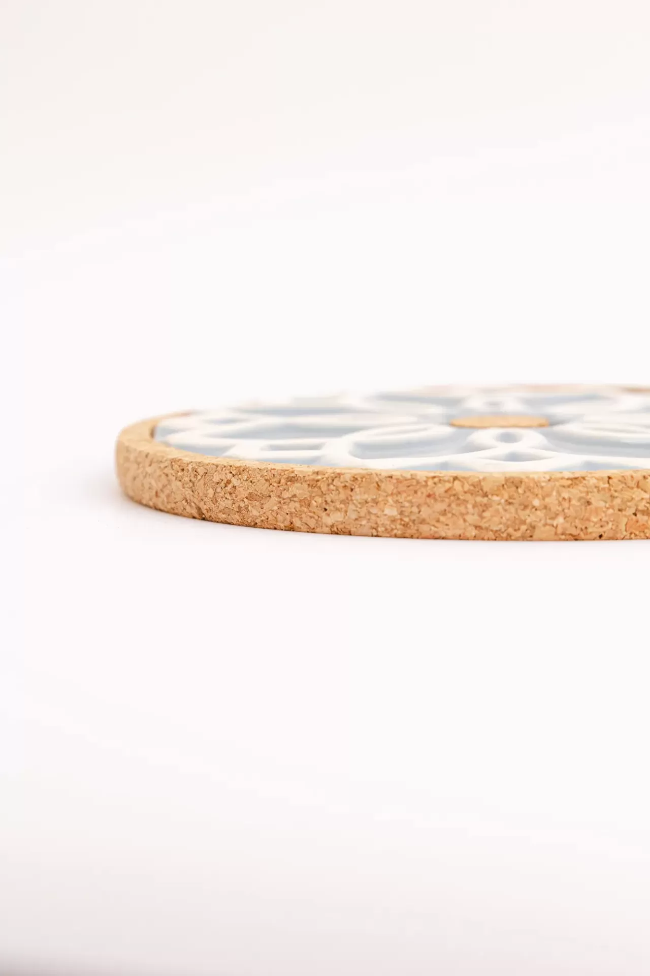 Suporte redondo para panela com borda em cortiça e padrão floral.