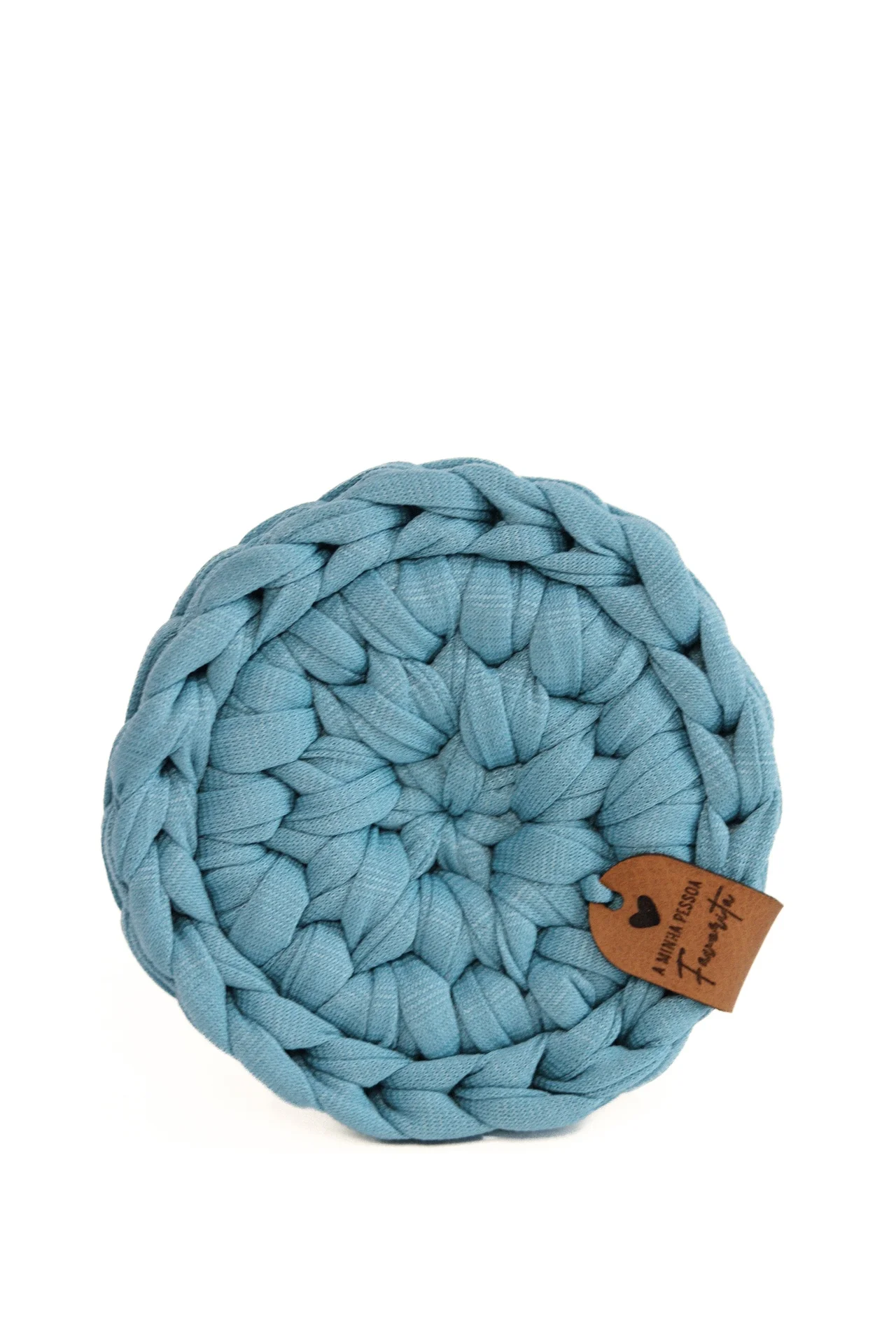 Base para copos redonda azul de tecido trançado com etiqueta de couro pendurada