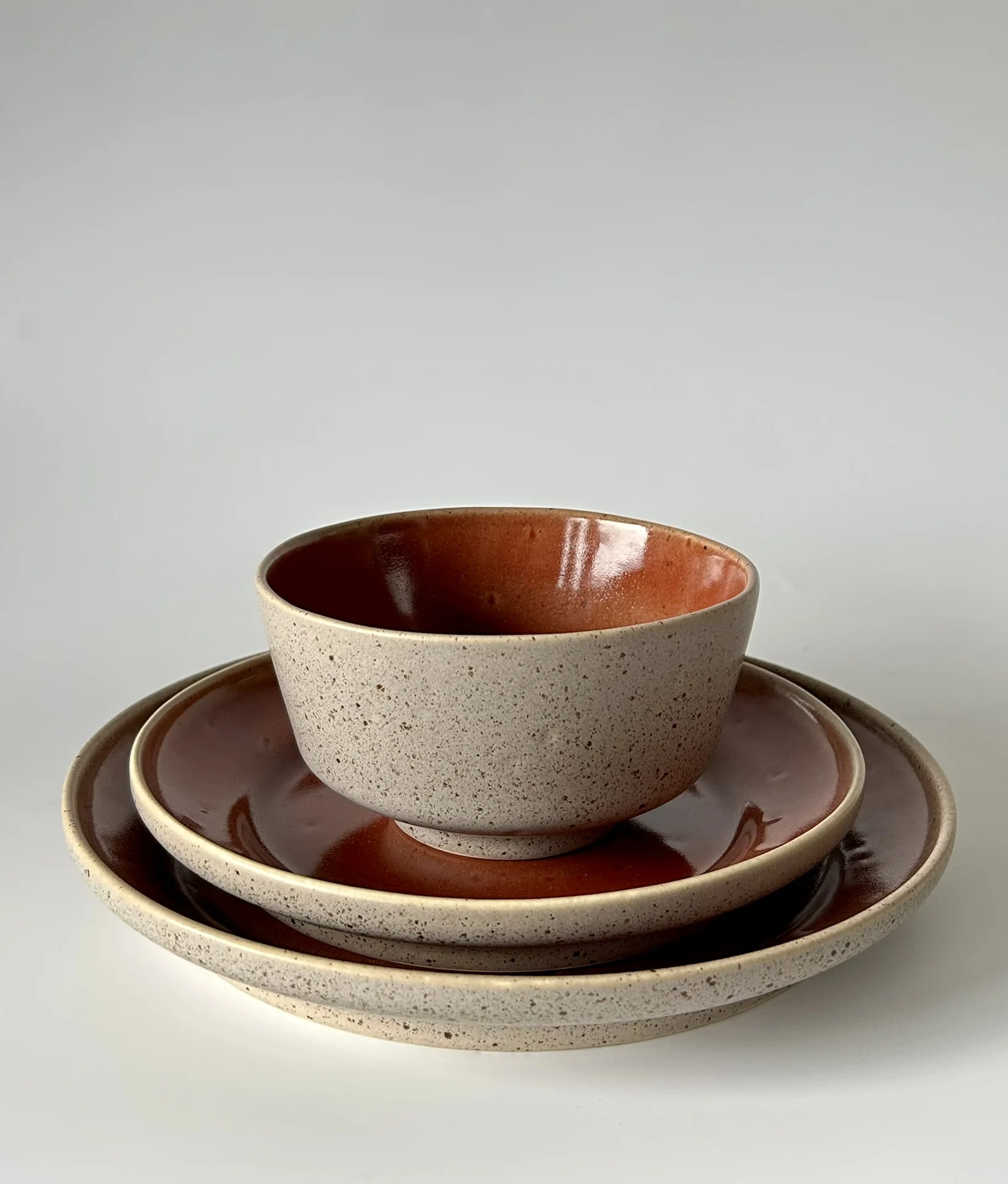 Conjunto de louça em cerâmica bege com interior castanho.