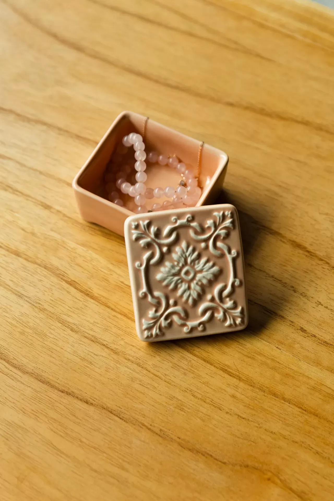 Caixa rosa de cerâmica decorada com corrente cor-de-rosa