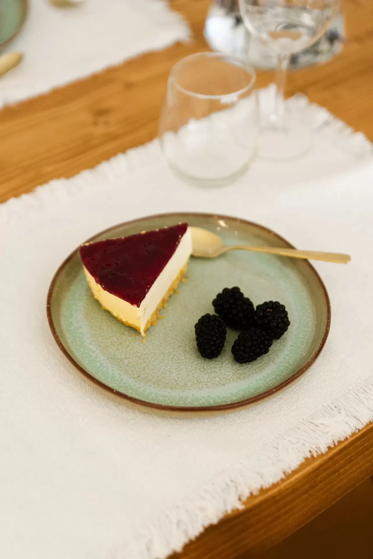 Fatia de cheesecake com amoras num prato cerâmico