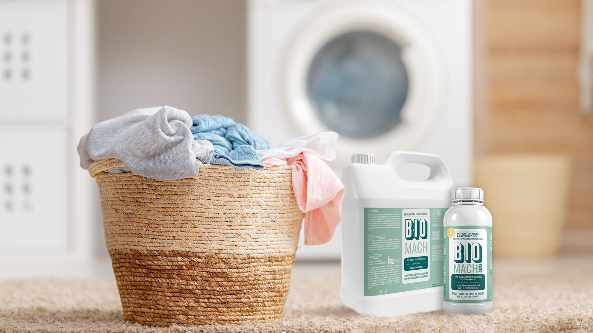 Detergente de roupa bio enzimático 2 em 1 - BIOMACH SUPER Original (frutado) Cesto de roupa com detergente BIO MACH ao lado, máquina de lavar ao fundo