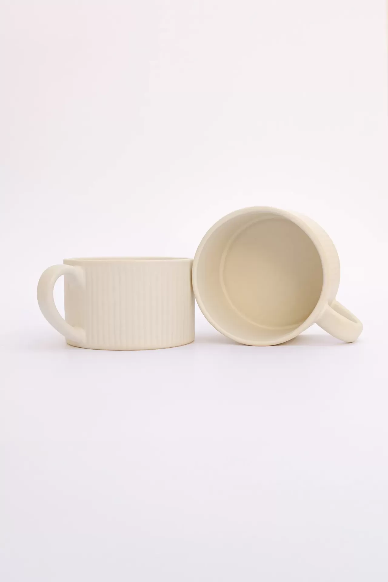 Conjunto de duas canecas creme de cerâmica com textura de linhas verticais