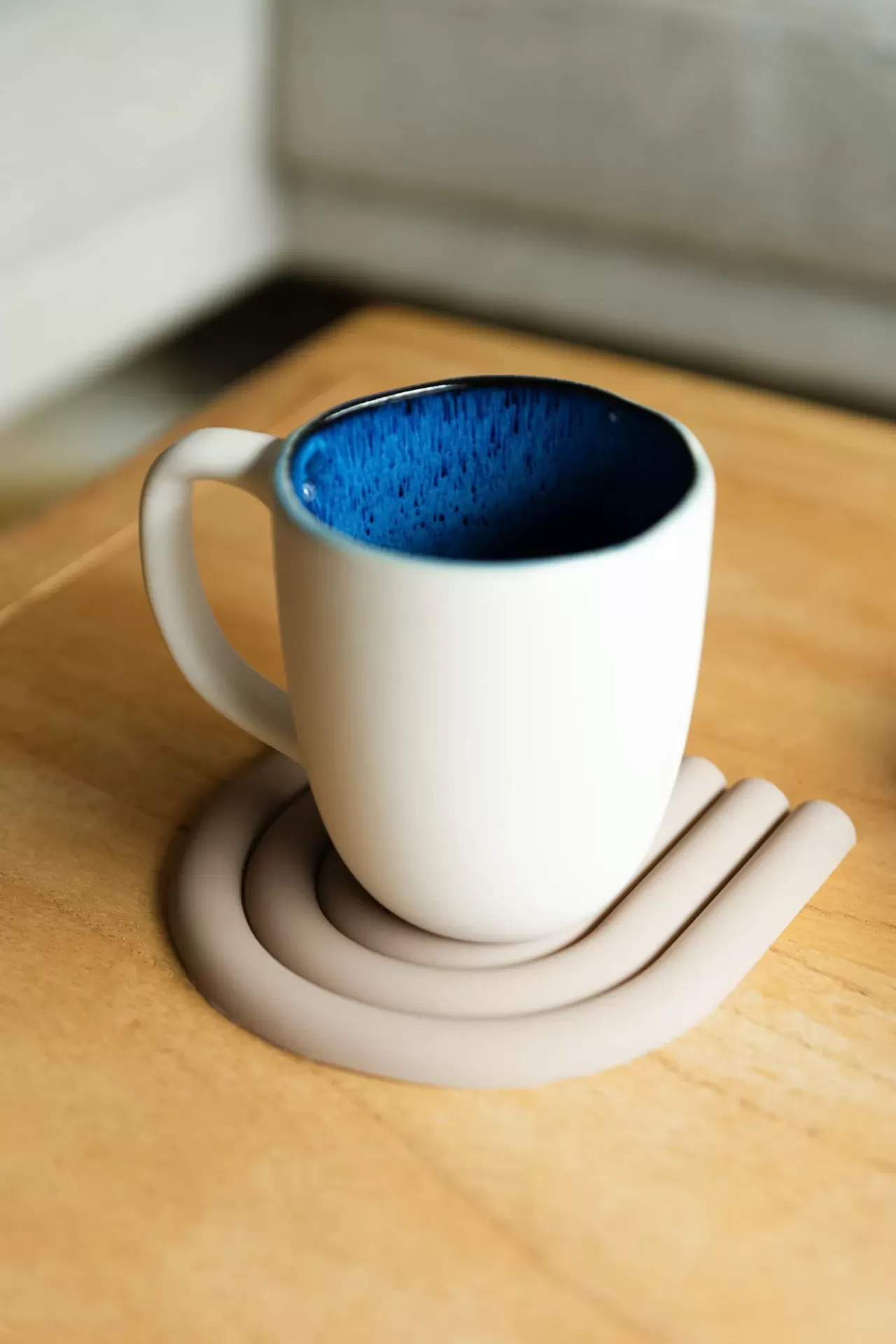 Caneca branca com interior azul numa mesa de madeira