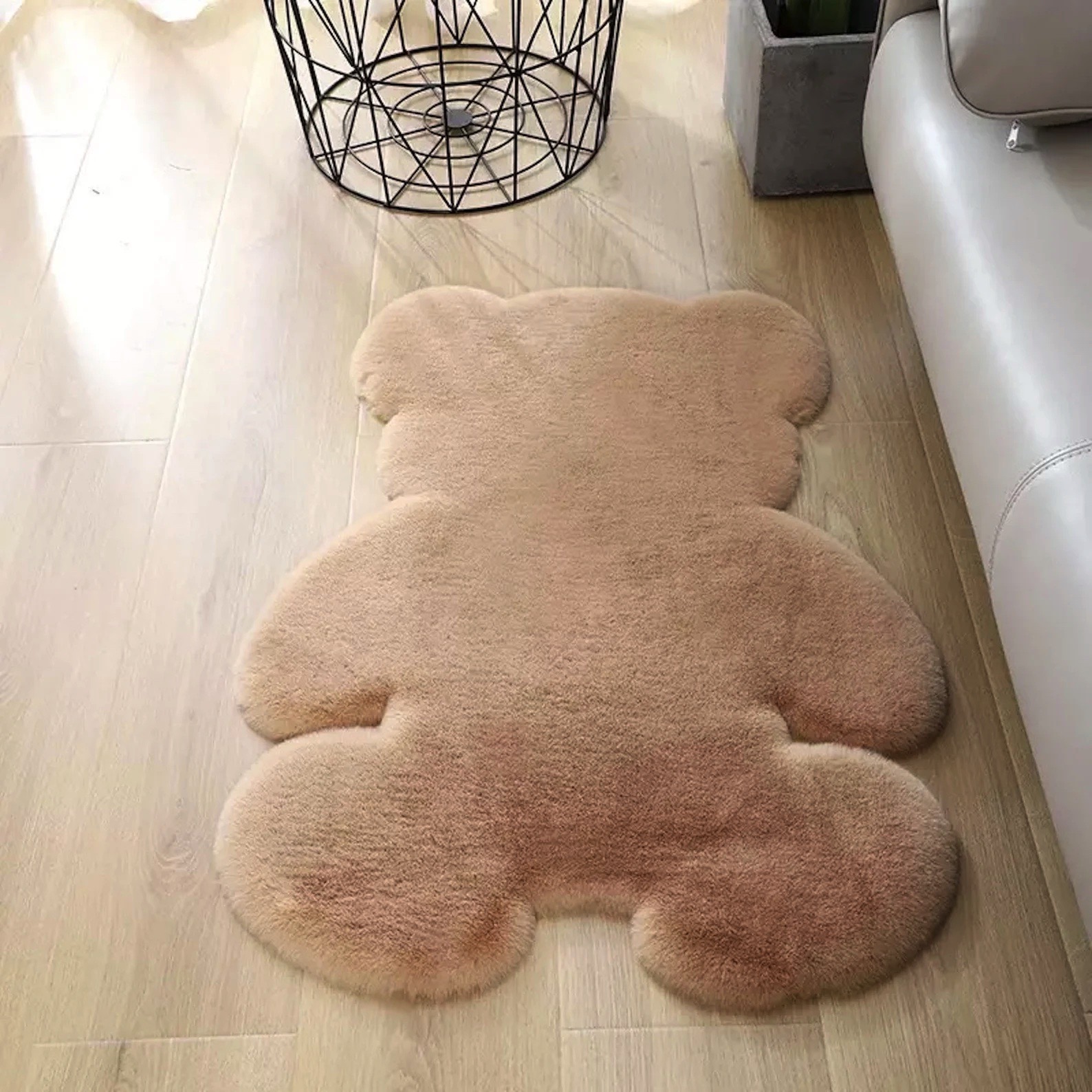 tapete de pelo sintético castanho claro em forma de urso junto a sofá