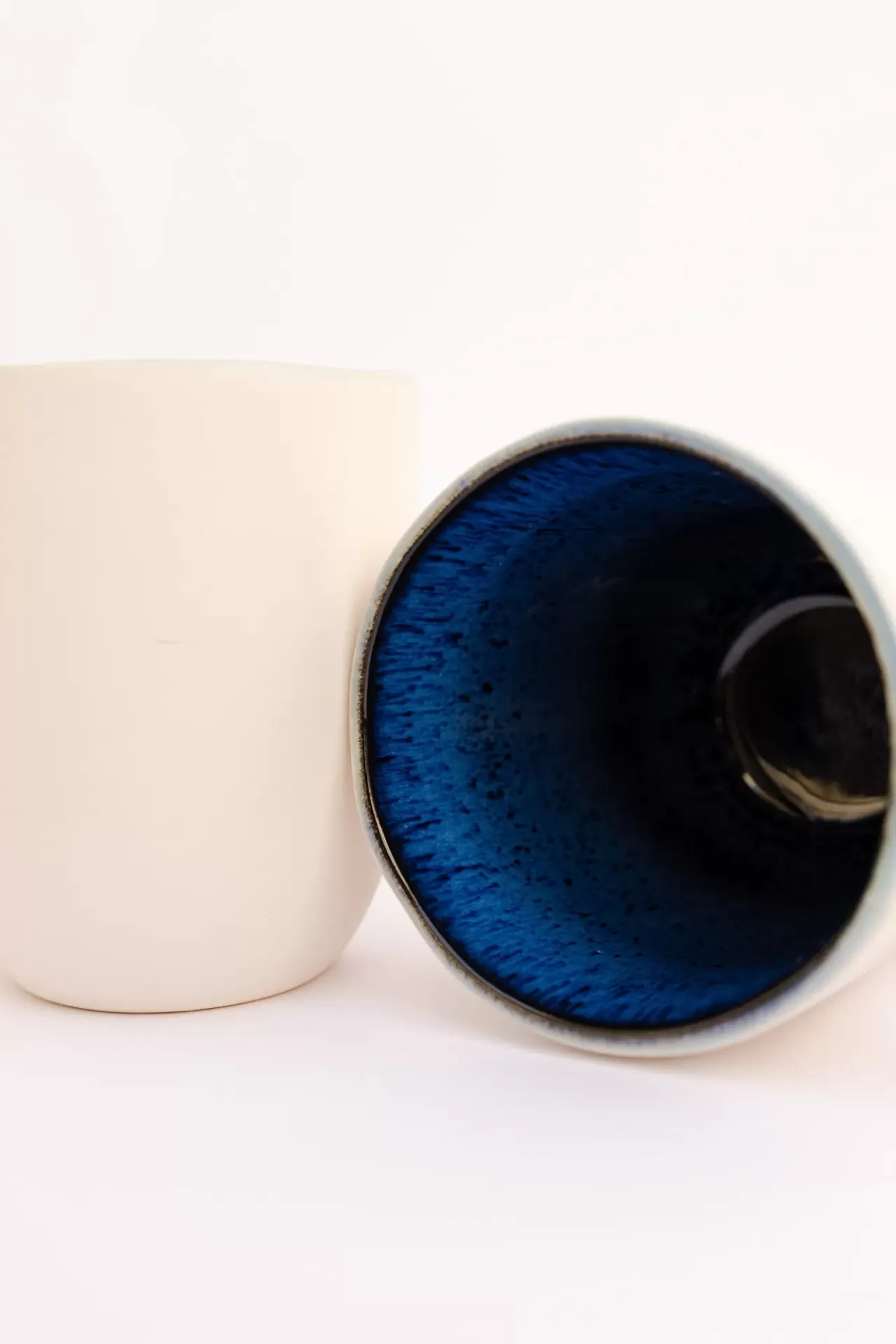Duas canecas de cerâmica com interior azul e exterior branco e cinza