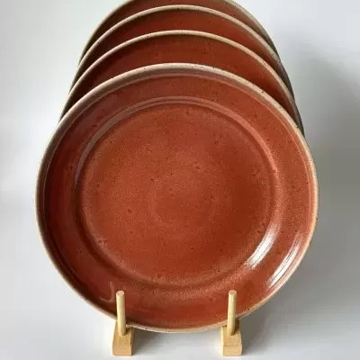 conjunto de pratos de cerâmica castanha em suporte de madeira