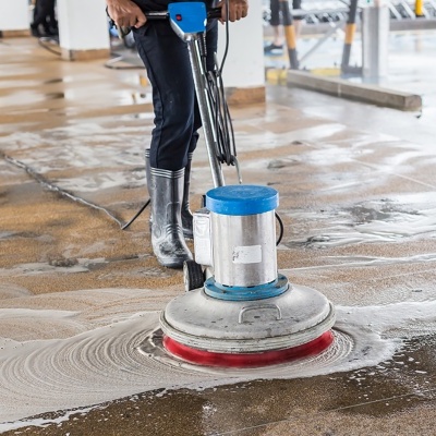 Máquina de limpeza industrial a limpar chão molhado num espaço interior amplo