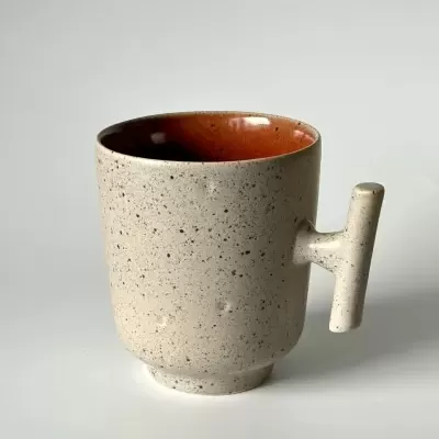 caneca de cerâmica salpicada bege com interior castanho