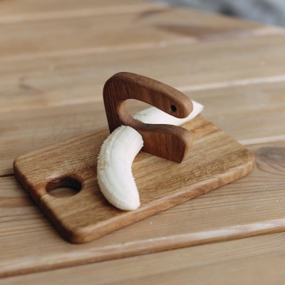 tabua de madeira clara com peça curva e pedaço de banana descascada