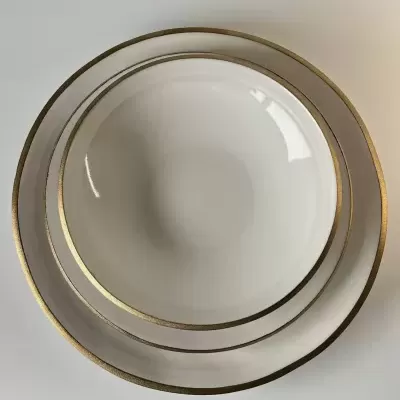 Dois pratos brancos com bordas douradas