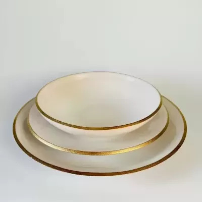 Pratos brancos cerâmica com bordas douradas empilhados