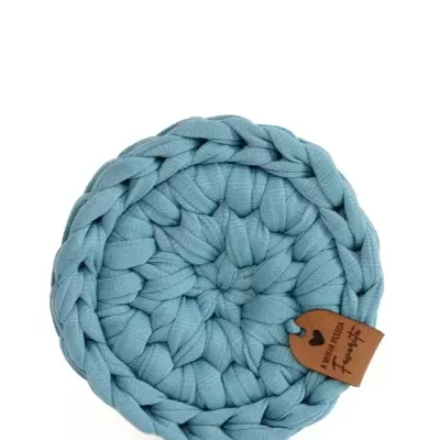 Base para copos redonda azul de tecido trançado com etiqueta de couro pendurada