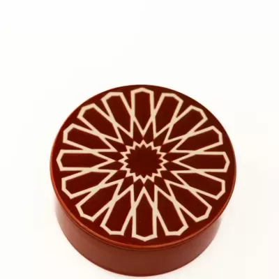 Caixa redonda castanha com padrão geométrico branco na tampa