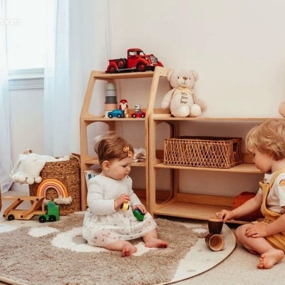 Quarto infantil com crianças, brinquedos de madeira e móveis claros