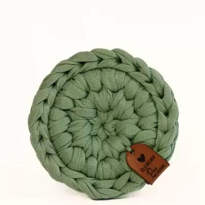 Base redonda trançada de tecido verde com etiqueta castanha de couro