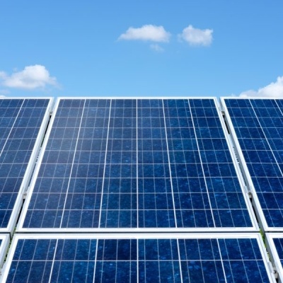 Painéis solares azuis sob céu azul com nuvens