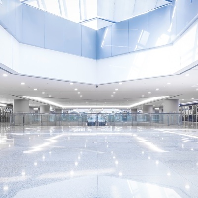 Interior moderno com piso de azulejos cinzentos e teto branco com iluminação