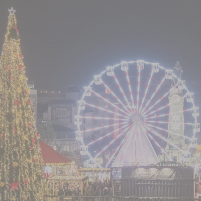 Árvore de Natal gigante iluminada e roda gigante numa praça à noite