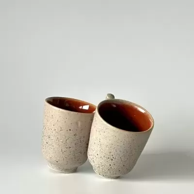 Duas canecas de cerâmica cinza texturizadas com interior castanho avermelhado