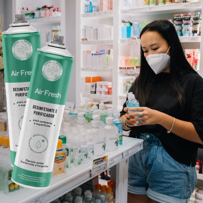 Mulher com máscara a segurar desinfetante para as mãos numa loja com produtos de beleza e higiene pessoal