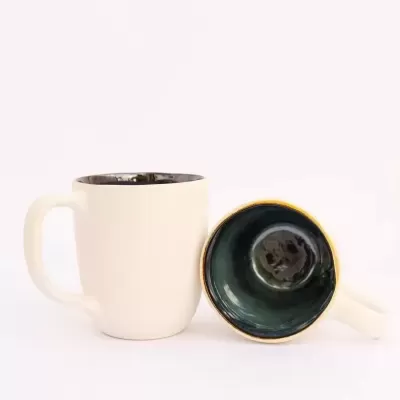 Duas canecas de cerâmica branca com interior azul em fundo branco