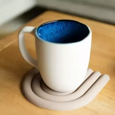 Caneca branca com interior azul numa mesa de madeira