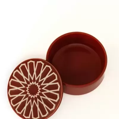 Caixa redonda castanha com tampa decorada com padrão geométrico bege