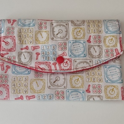 Carteira com padrão colorido de números e blocos, botão vermelho