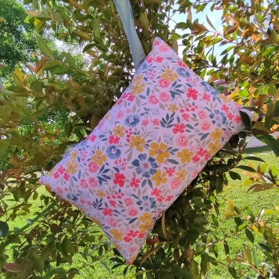 Almofada retangular floral com alça cinza em ambiente exterior