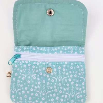 Carteira azul claro com padrão floral branco e fechos metálicos