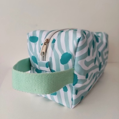 Estojo retangular azul e verde com padrão riscado e pega larga