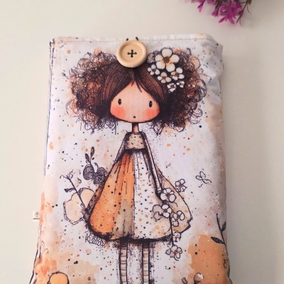Almofada com desenho de menina de vestido laranja e bege com flores e botão no topo