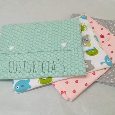 Quatro capas de almofadas em tecidos coloridos com diferentes padrões, incluindo hexágonos, animais, corações e estrelas